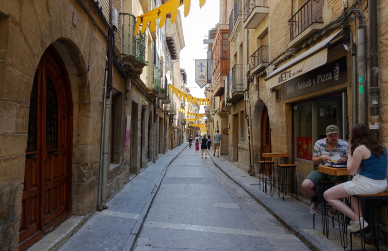 11 - A charming medieval street in Olite, Navarre, Spain, adorned with festive yellow banners overhead
